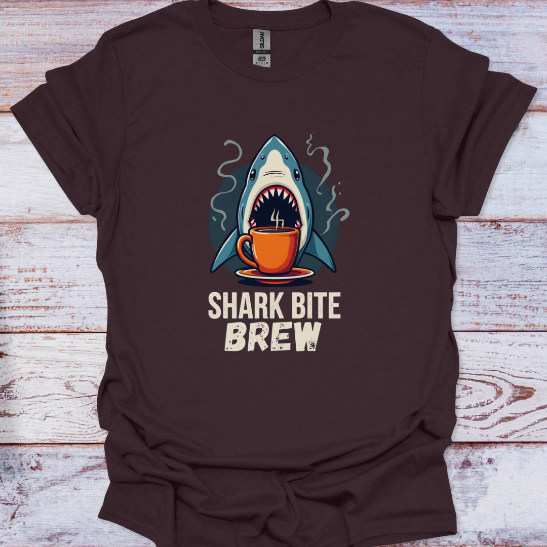Brown t-shirt with a shark drinking coffee graphic and 'Shark Bite Brew' text on a wooden surface.