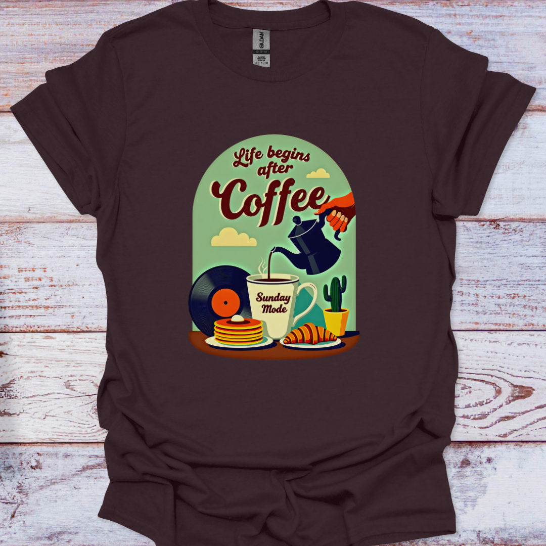 Brown t-shirt with a graphic design of coffee-themed illustrations on a wooden surface.