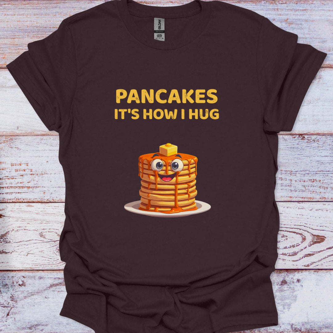 Brown t-shirt with cartoon pancakes and text on a wooden surface
