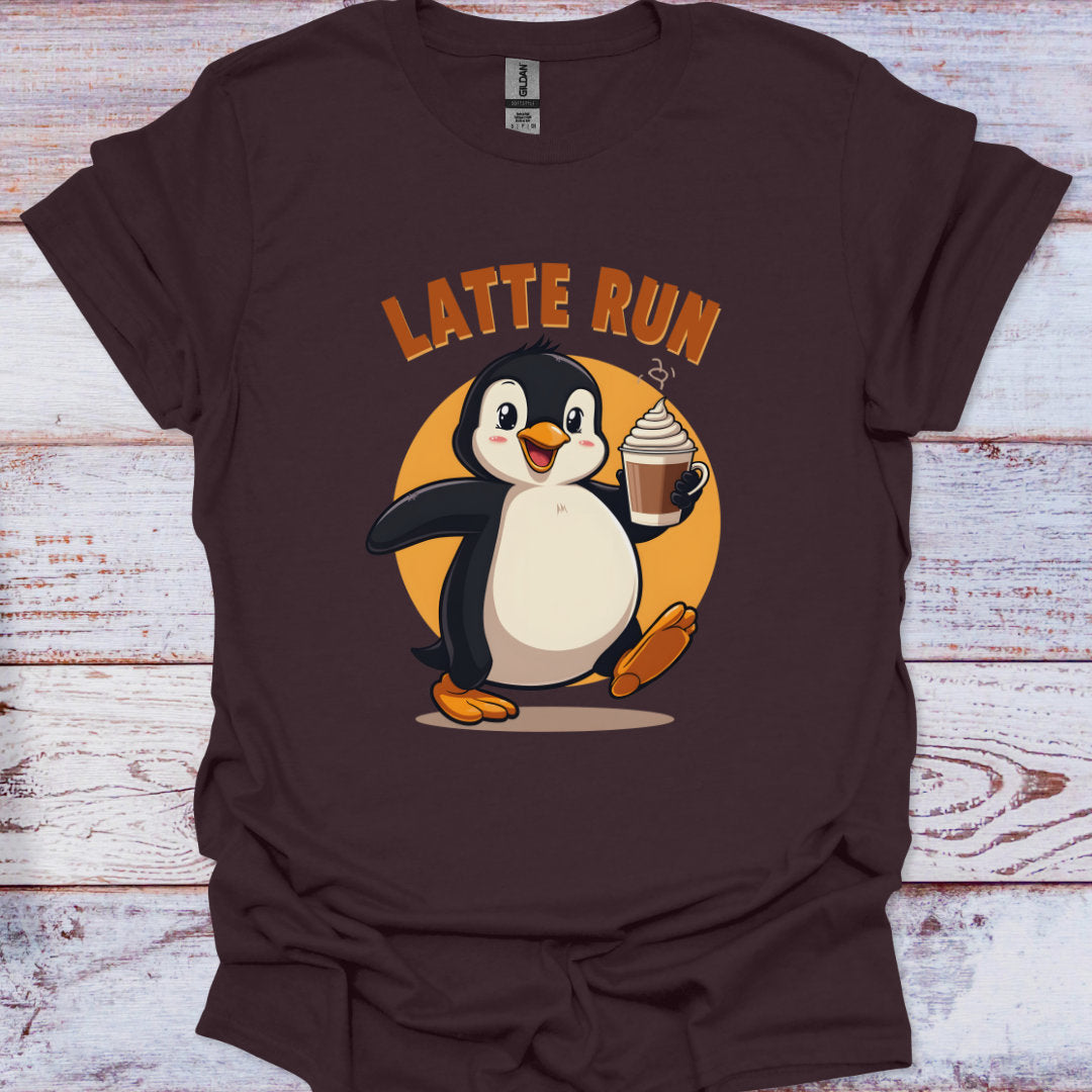 Brown t-shirt with a penguin holding a cup of coffee and 'Latte Run' text on a wooden surface