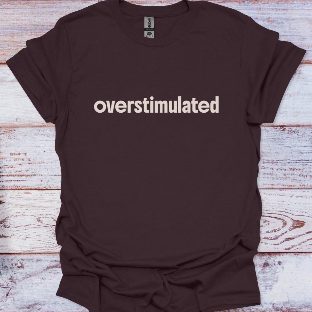 Brown t-shirt with 'overstimulated' text on a wooden surface