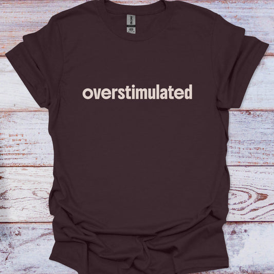 Brown t-shirt with 'overstimulated' text on a wooden surface