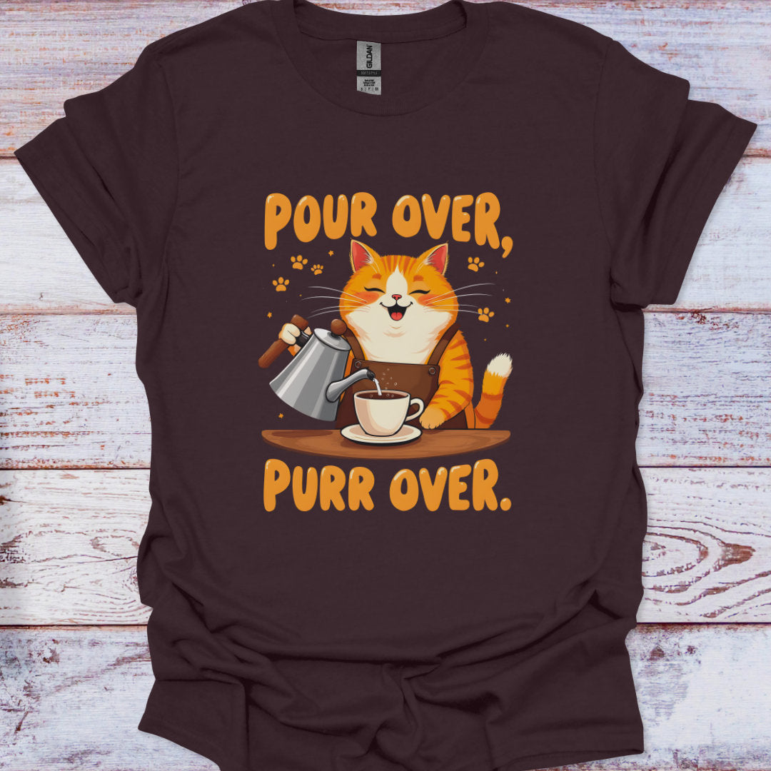 Brown t-shirt with a cat pouring coffee and 'Pour Over, Purr Over' text on a wooden surface.