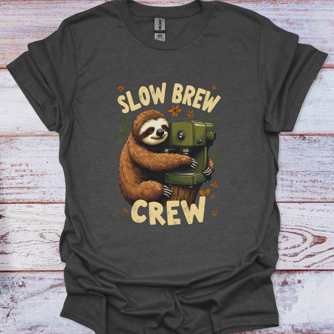 Dark gray t-shirt with a sloth holding a coffee press and 'Slow Brew Crew' text on a wooden surface.