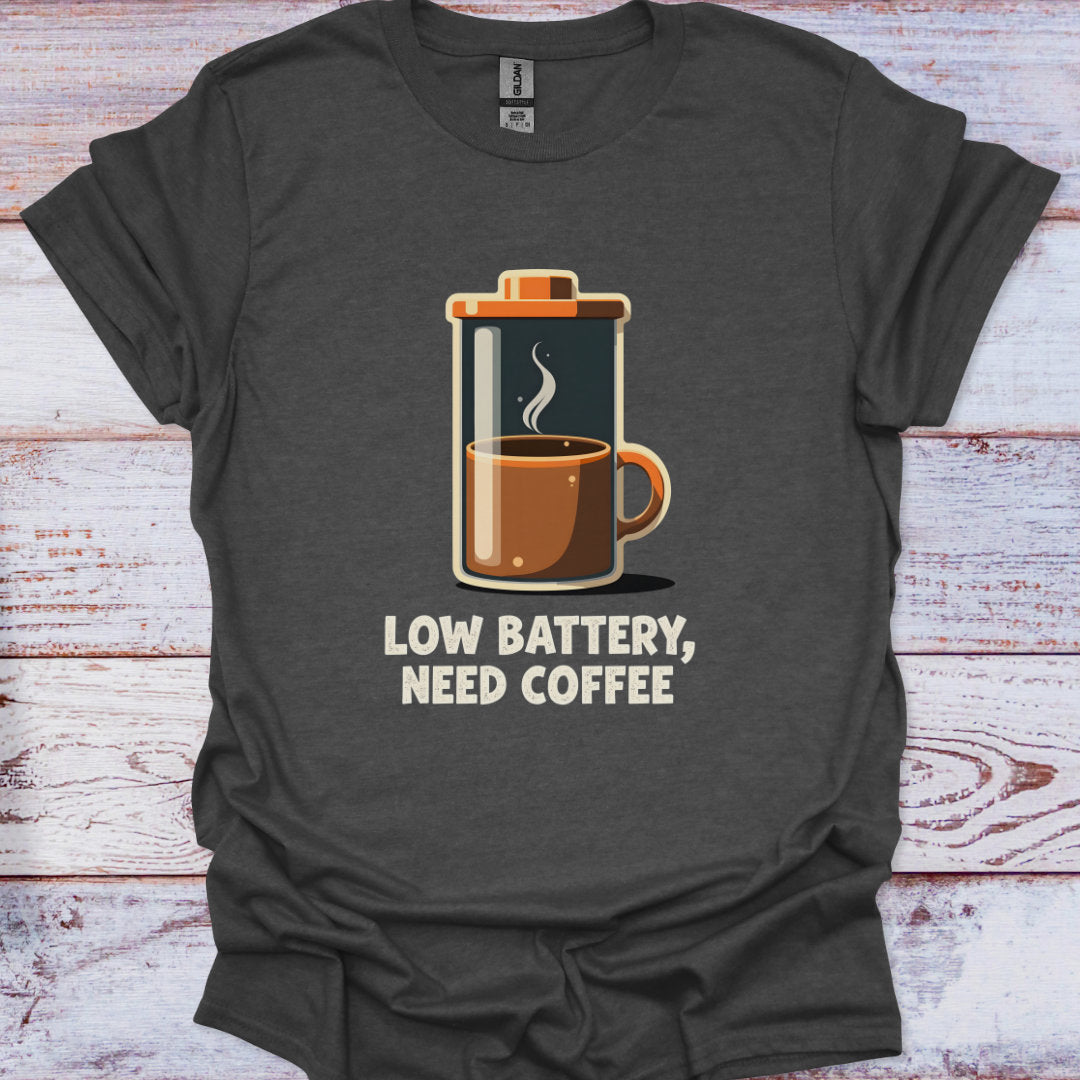 Dark gray t-shirt with a graphic of a French press and 'Low Battery, Need Coffee' text on a wooden surface.