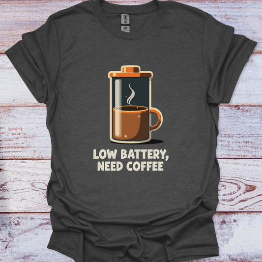 Dark gray t-shirt with a graphic of a French press and 'Low Battery, Need Coffee' text on a wooden surface.