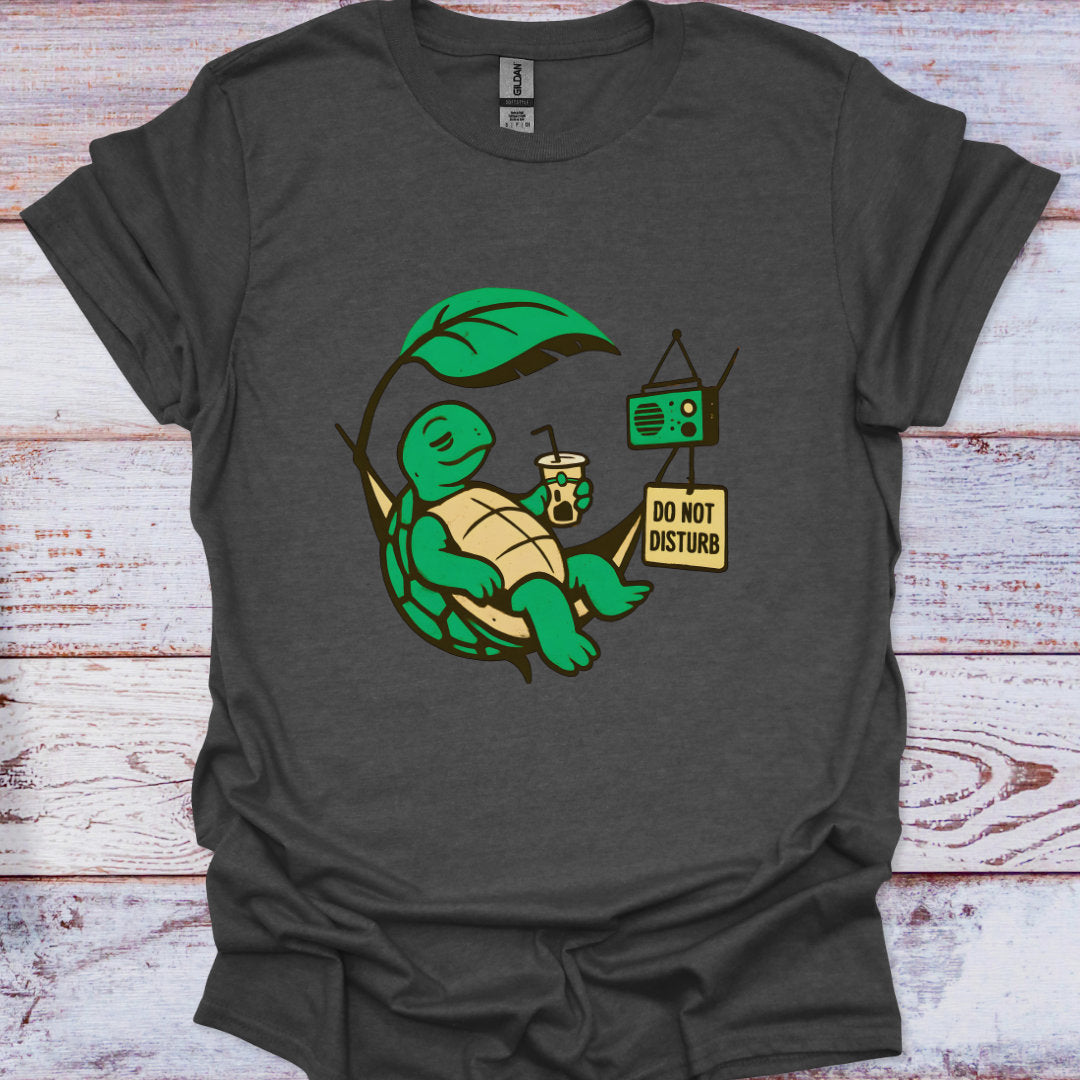 Dark gray t-shirt with a green turtle graphic and 'Do Not Disturb' sign on a wooden surface