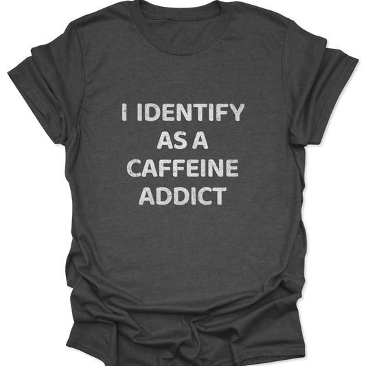 A dark heather gray shirt with a high-contrast graphic reading "I IDENTIFY AS A CAFFEINE ADDICT" in a textured block font.