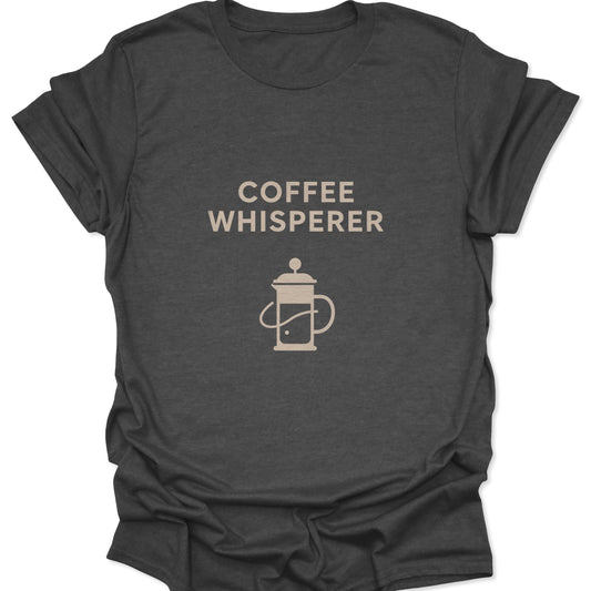 Graphic tee in dark heather gray with a sand-colored French Press graphic and bold "Coffee Whisperer" header.