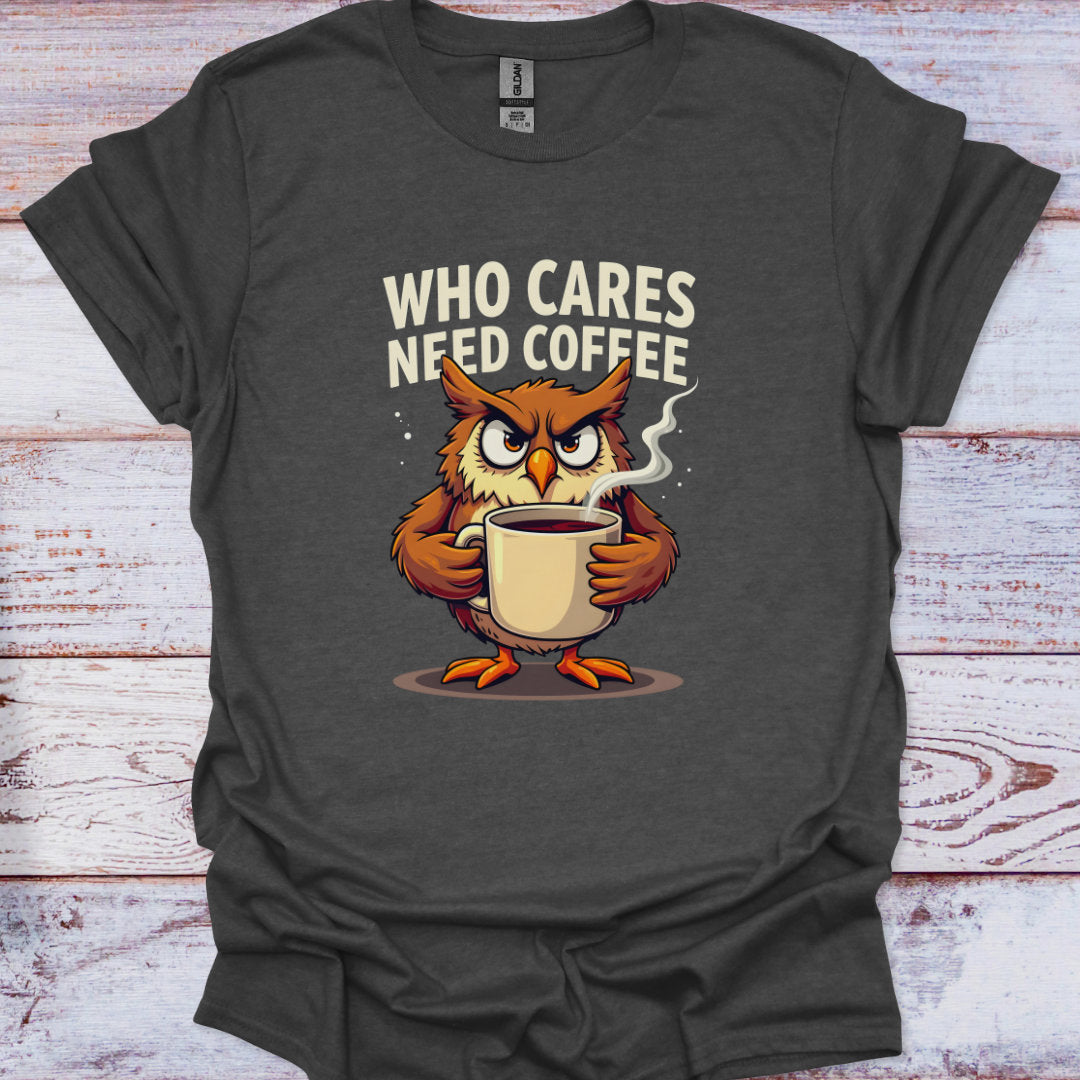 Dark gray t-shirt with an owl holding a coffee cup and text 'WHO CARES NEED COFFEE' on a wooden surface.