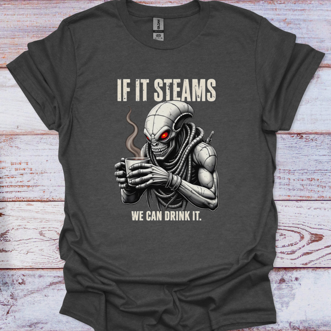 T-shirt with alien holding a coffee cup and text 'If it steams, we can drink it' on a wooden surface.