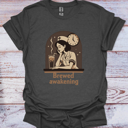 Dark gray t-shirt with a graphic of a woman drinking coffee and text 'Brewed awakening' on a wooden surface.