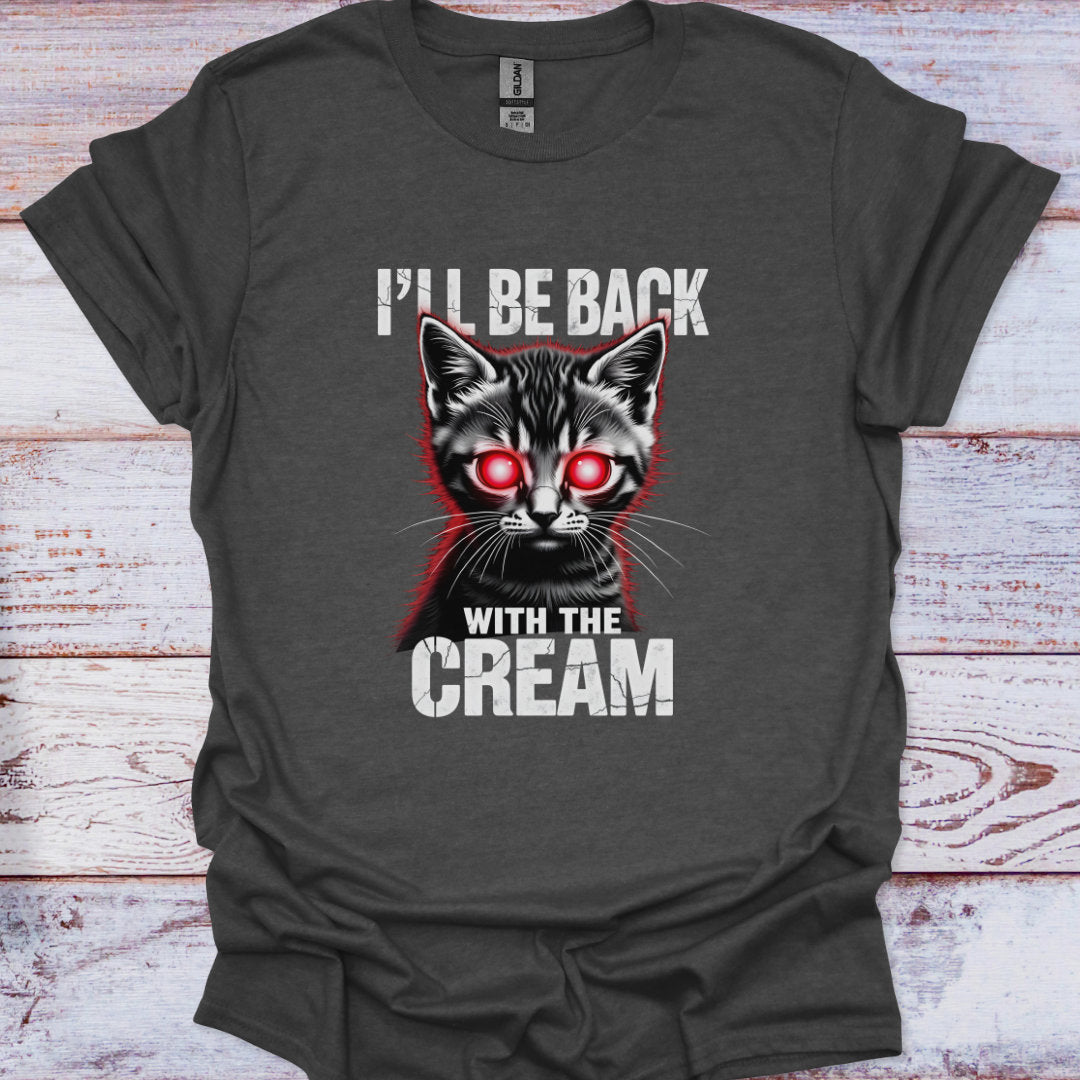 Gray t-shirt with a graphic of a cat with red eyes and text 'I'll be back with the cream' on a wooden surface.