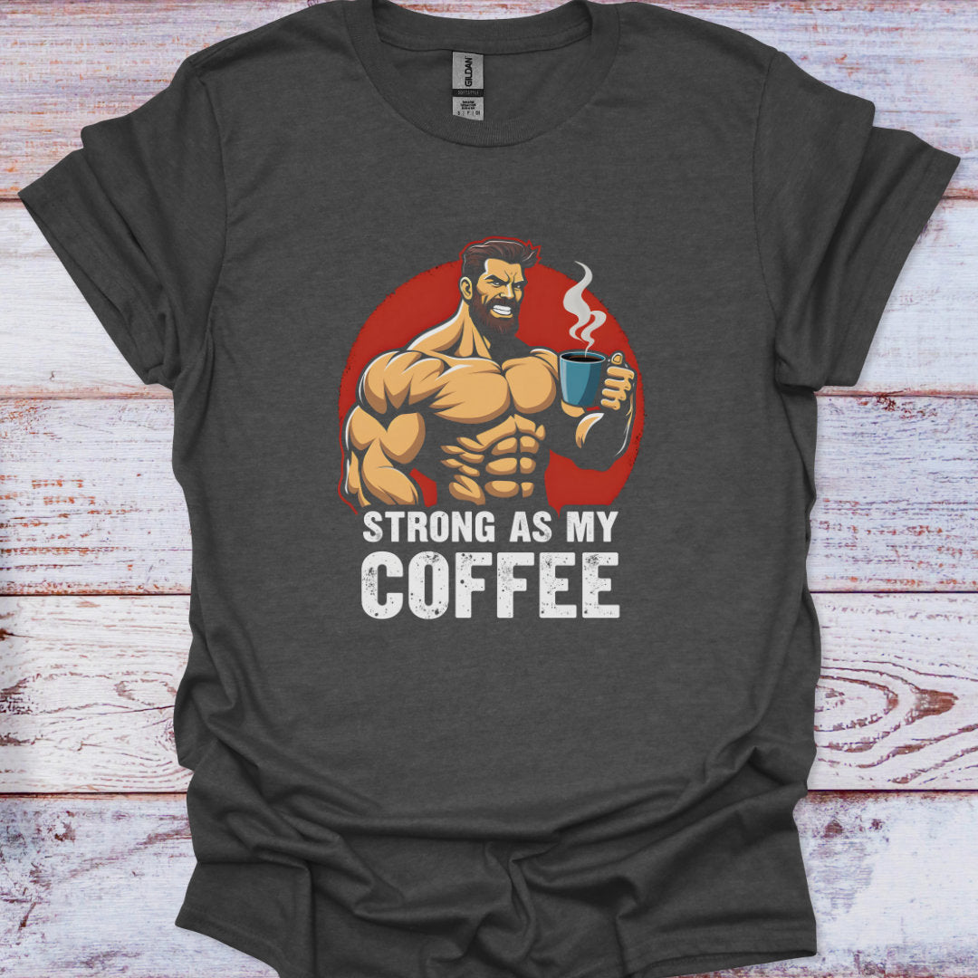 Dark gray t-shirt with a graphic of a muscular man holding a coffee cup and text 'Strong as my coffee' on a wooden surface.