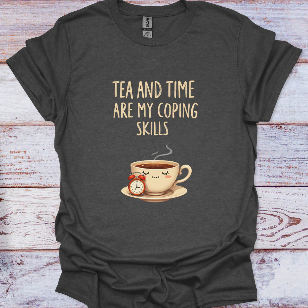 Dark gray t-shirt with a graphic of a teacup and clock, and text 'Tea and time are my coping skills' on a wooden surface.