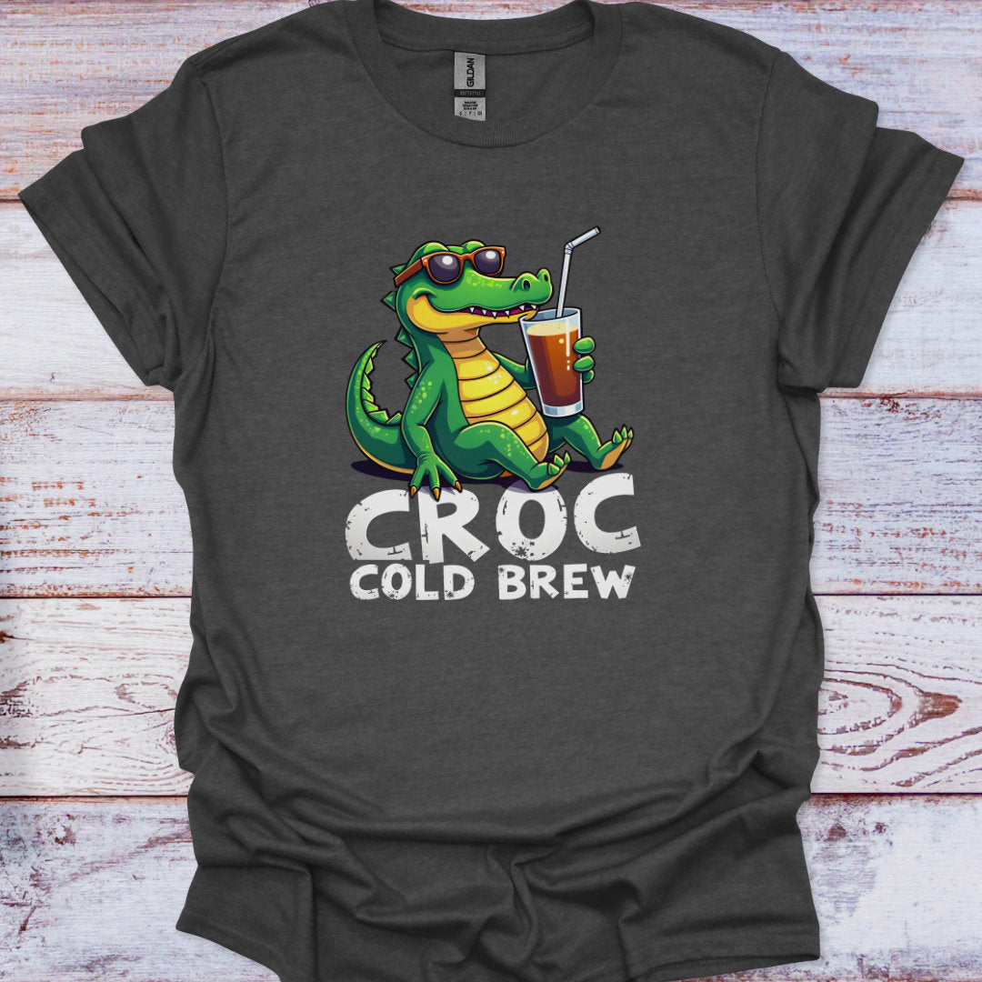 Dark gray t-shirt with a cartoon crocodile holding a cup labeled 'Croc Cold Brew' on a wooden surface.