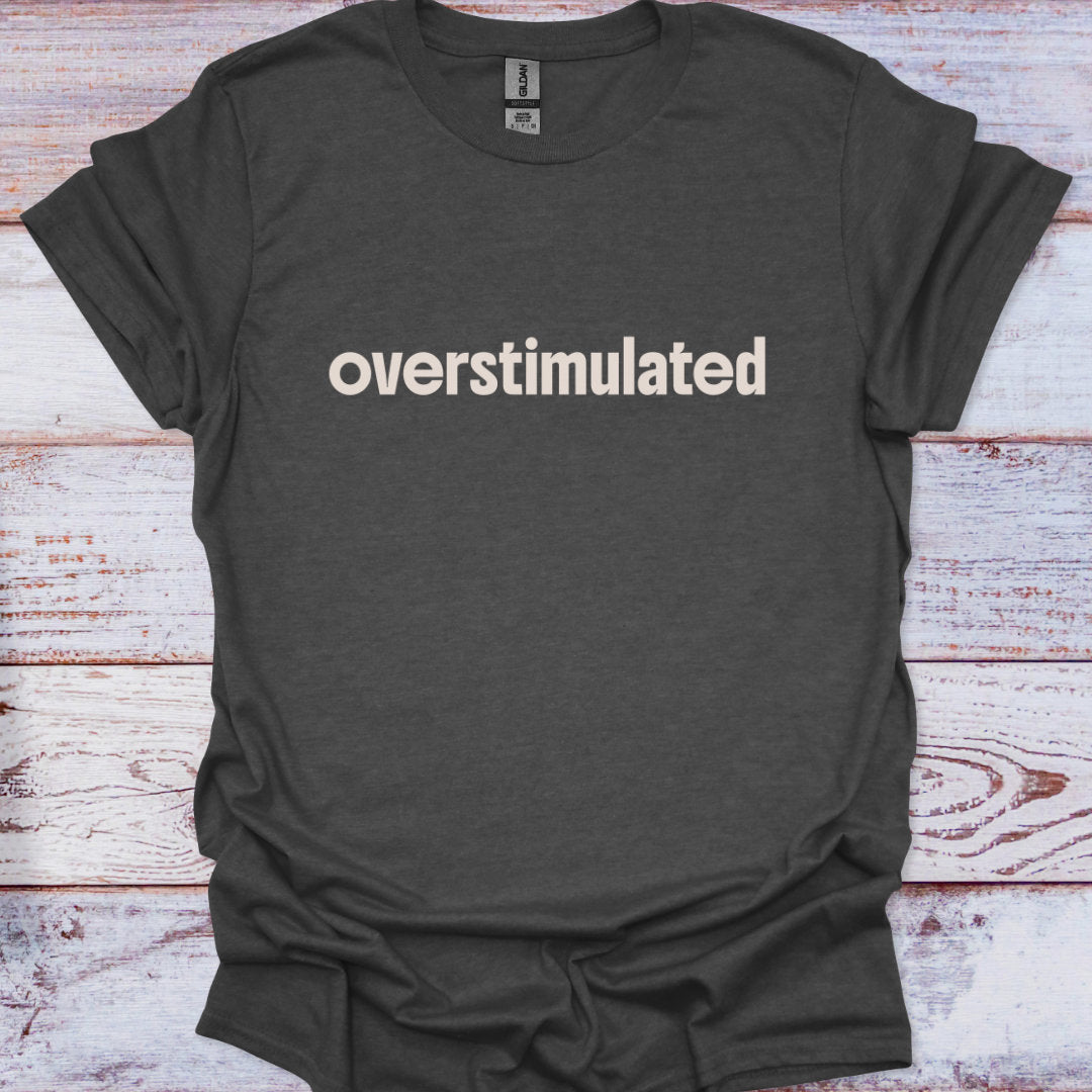 Dark gray t-shirt with 'overstimulated' text on a wooden surface