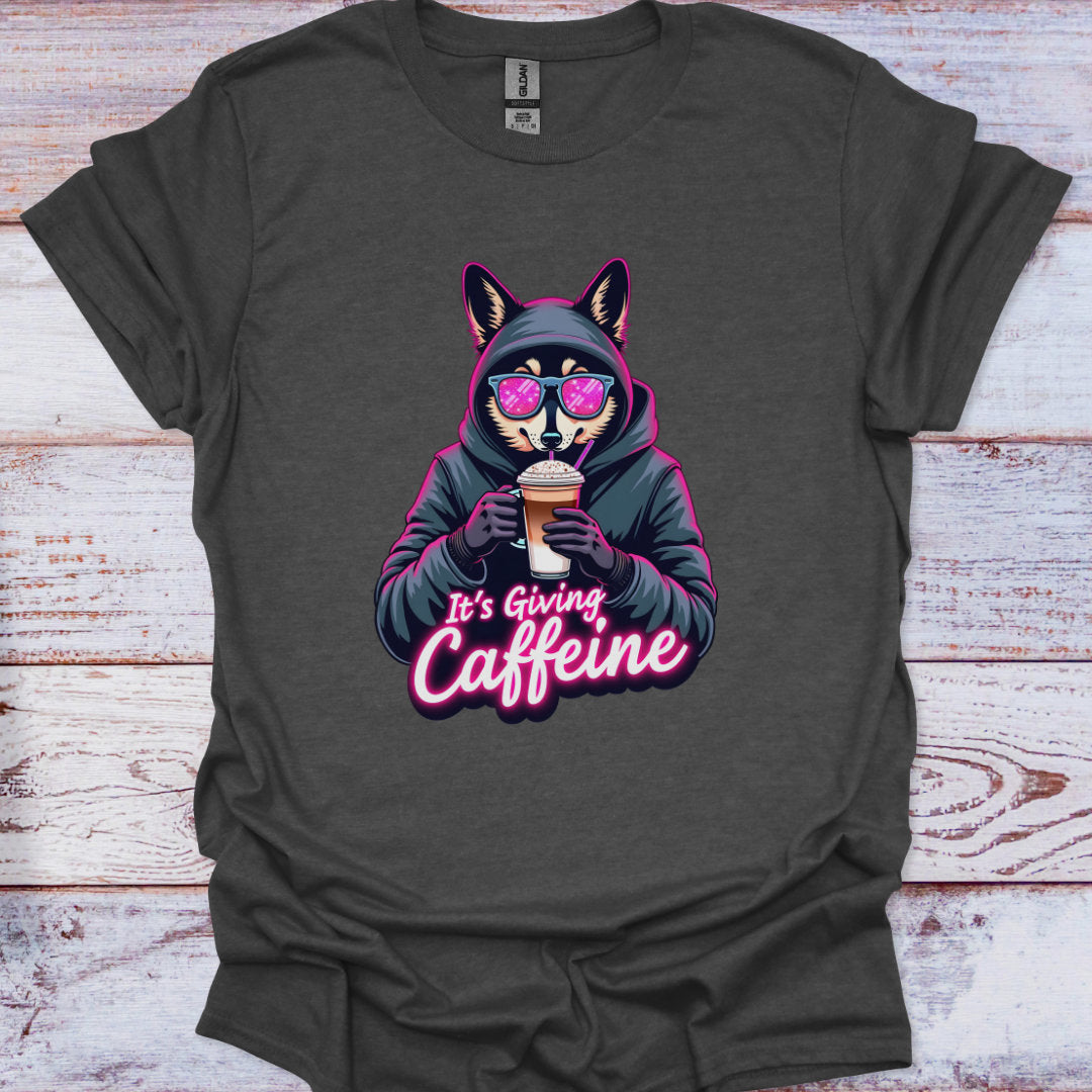 Dark gray t-shirt with a graphic of a fox holding a coffee cup and text 'It's Giving Caffeine' on a wooden surface.