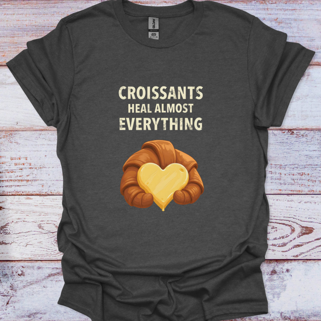Dark gray t-shirt with a croissant graphic and text on a wooden surface