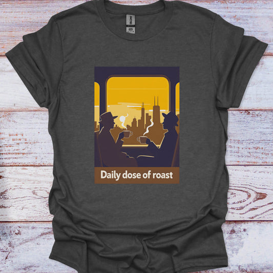 Dark gray t-shirt with graphic of two people in a car and city skyline, text 'Daily dose of roast' on a wooden surface.