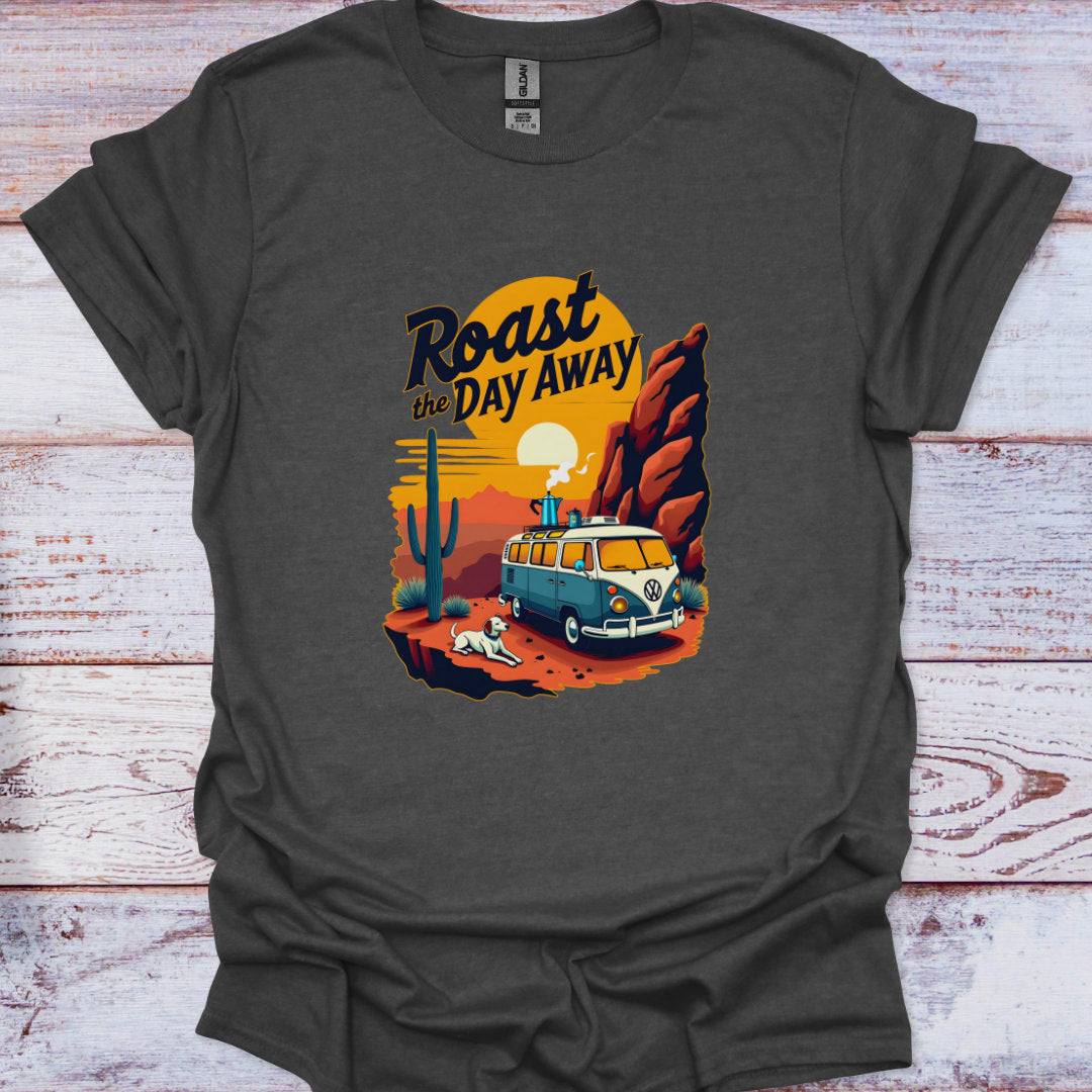 Gray t-shirt with a graphic design of a van, cactus, and sunset text 'Roast the Day Away' on a wooden surface.