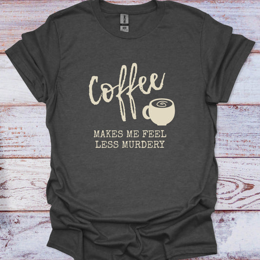 Dark gray t-shirt with 'Coffee makes me feel less murdery' text and coffee cup graphic on a wooden surface.