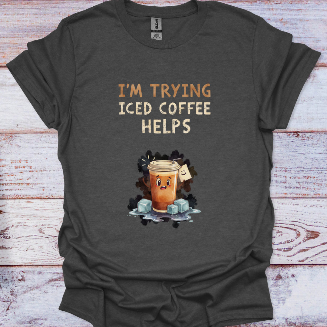 Dark gray t-shirt with iced coffee graphic and text 'I'm trying iced coffee helps' on a wooden surface.