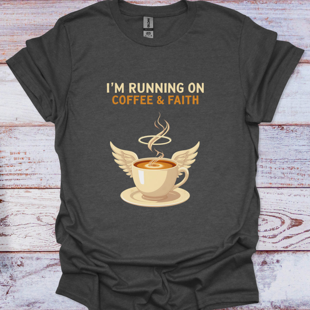 Dark gray t-shirt with a graphic of a coffee cup with wings and text 'I'm running on coffee & faith' on a wooden surface.