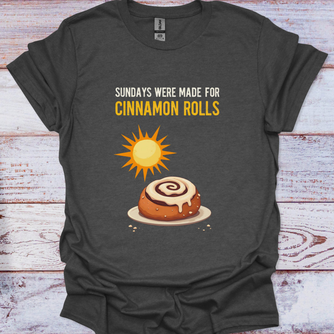 Dark gray t-shirt with a cinnamon roll graphic and text on a wooden surface