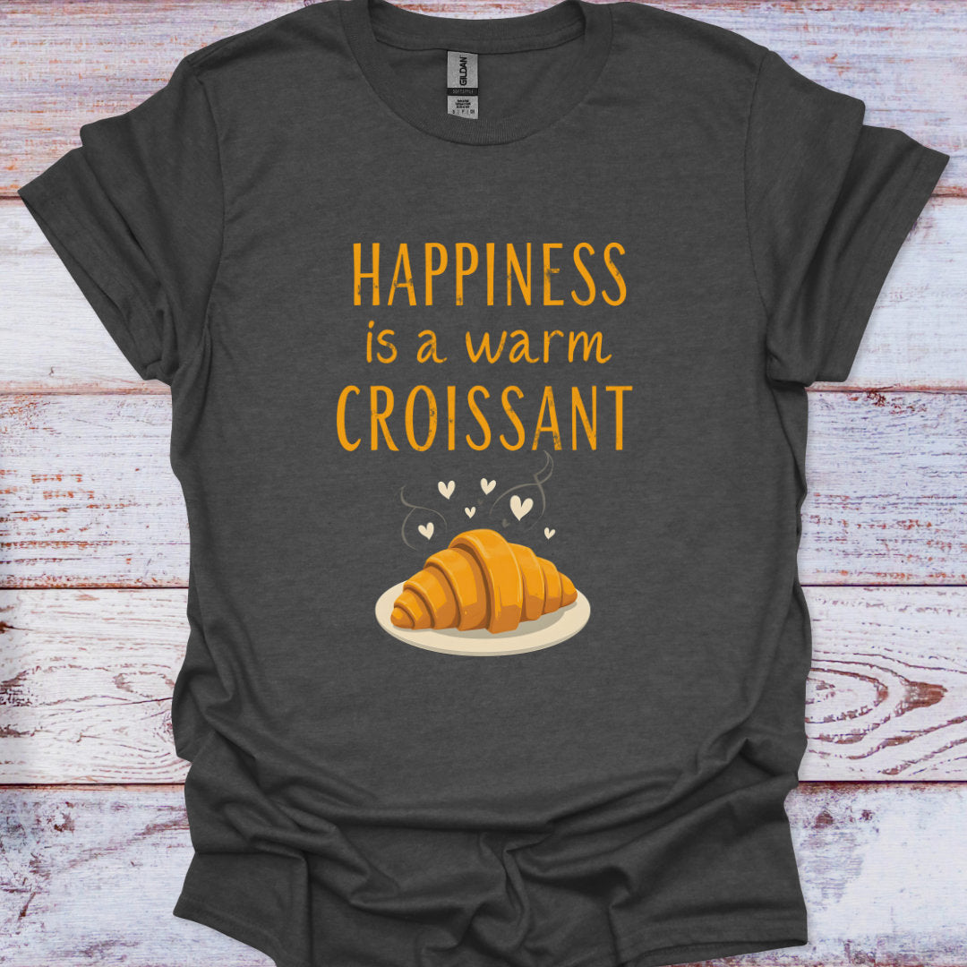 Dark gray t-shirt with 'Happiness is a warm croissant' text and croissant graphic on a wooden surface