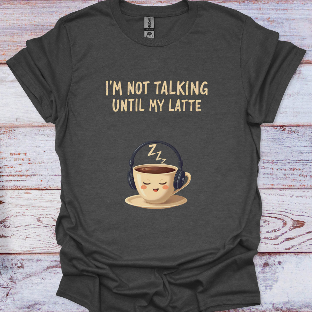 Dark gray t-shirt with a coffee cup wearing headphones and text 'I'm not talking until my latte' on a wooden surface.