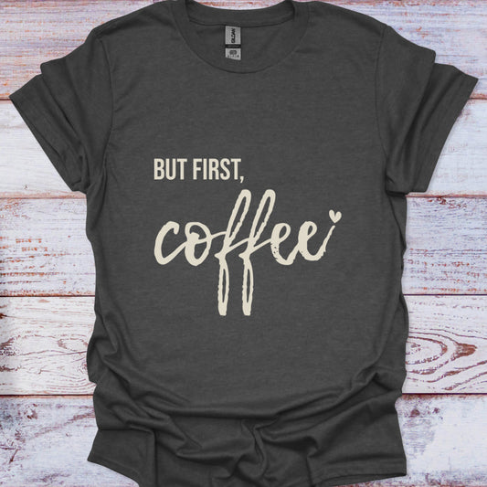Dark gray t-shirt with 'But first, coffee' text on a wooden surface
