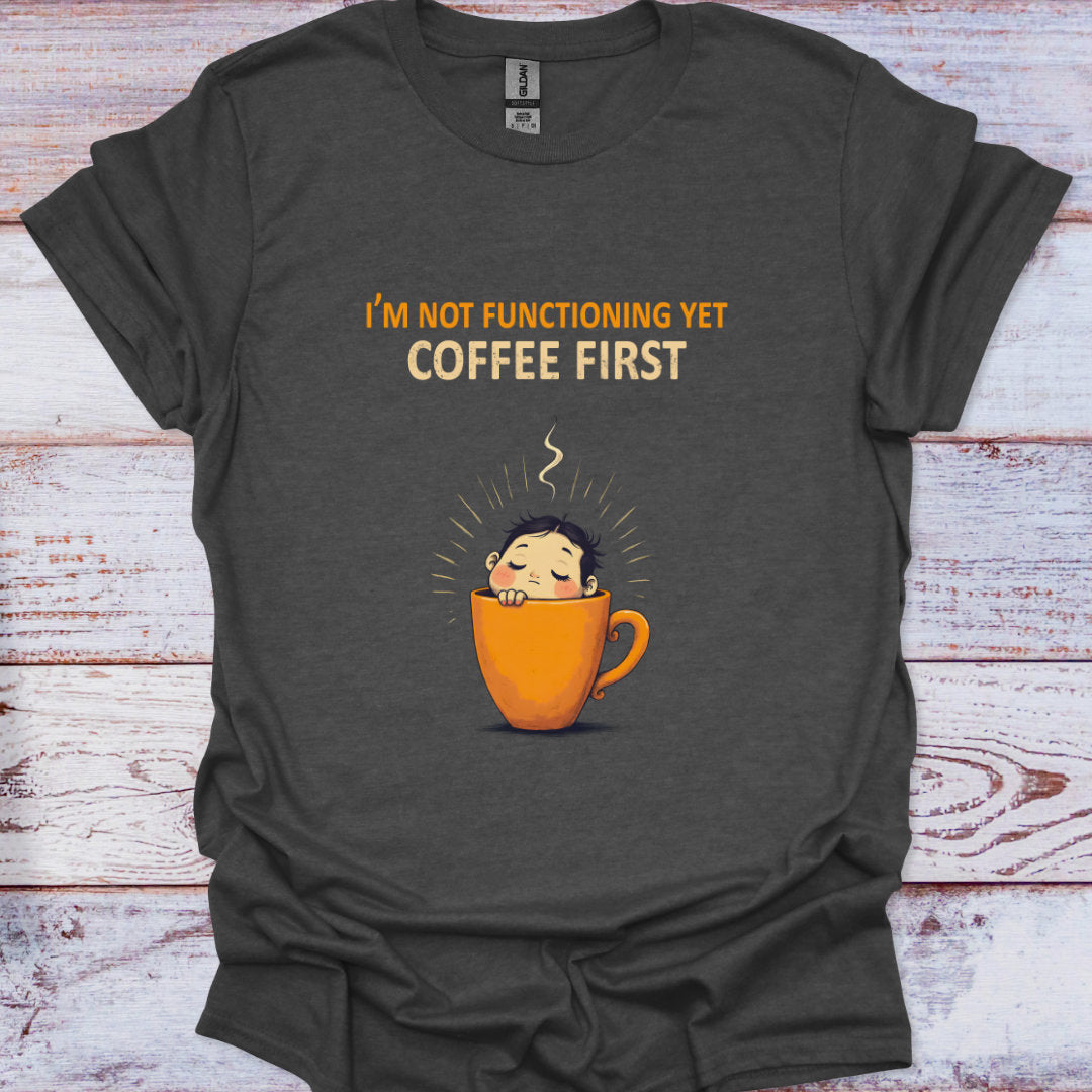 Dark gray t-shirt with a coffee cup graphic and text on a wooden surface