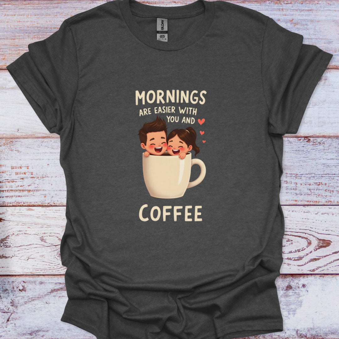 Dark gray t-shirt with cartoon design and text 'Mornings are easier with you and coffee' on a wooden surface.