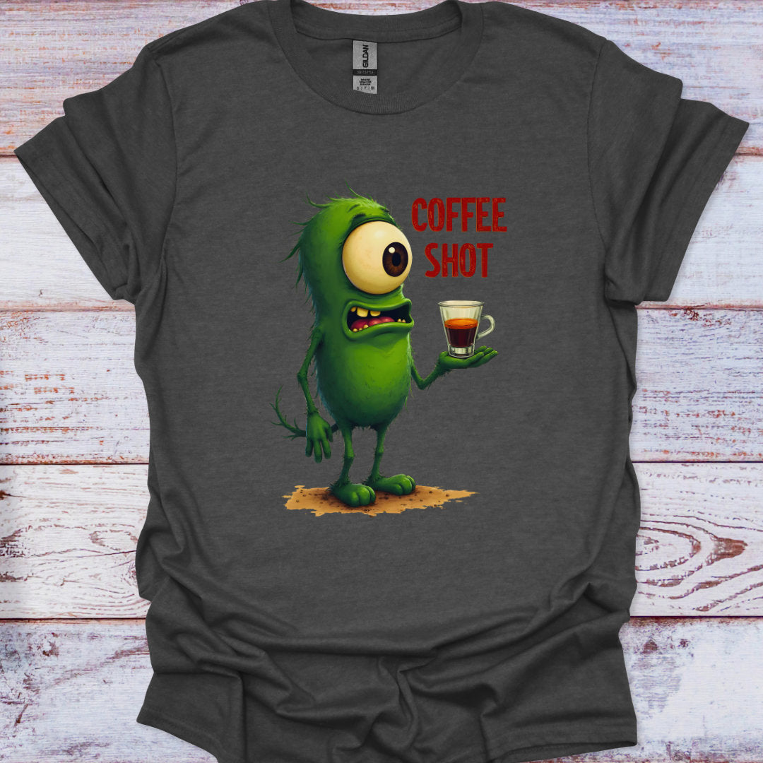 Gray t-shirt with a green monster holding a coffee shot graphic on a wooden surface