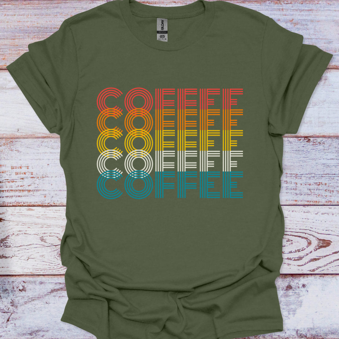 Green t-shirt with 'COFFEE' graphic in rainbow colors on a wooden surface