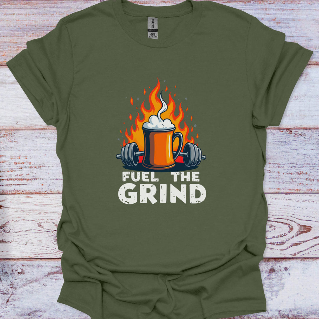 Green t-shirt with a graphic of a mug with flames, weights, and 'Fuel the Grind' text on a wooden surface.