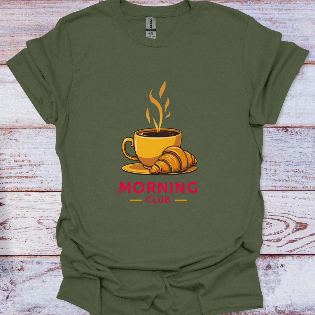 Green t-shirt with a coffee cup and croissant graphic and 'Morning Club' text on a wooden surface.
