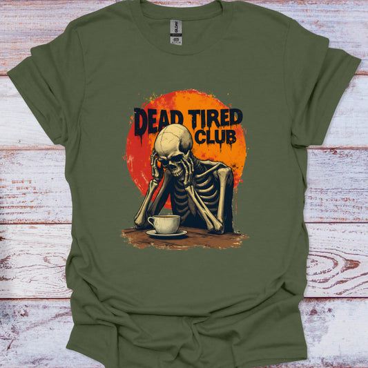 Green t-shirt with a skeleton and 'Dead Tired Club' design on a wooden surface
