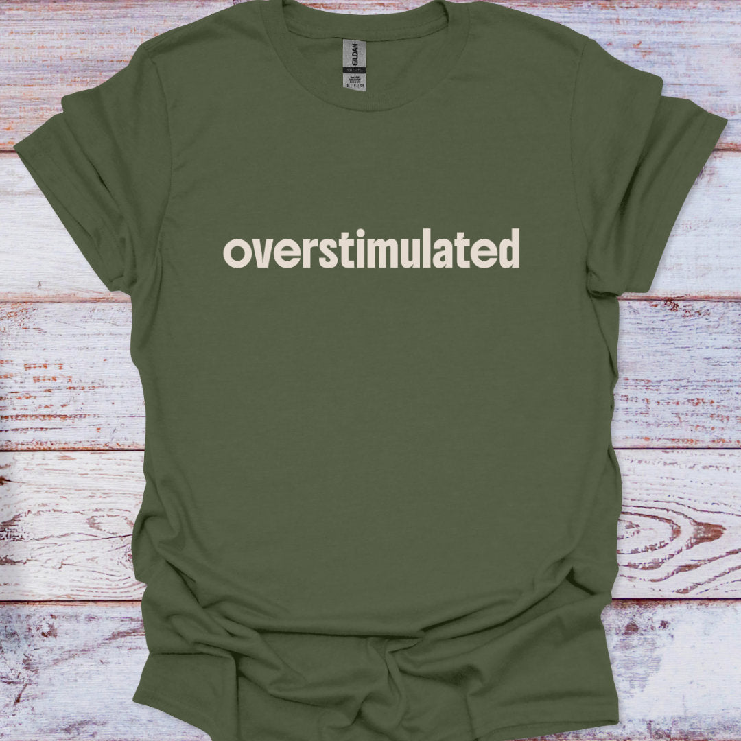Green t-shirt with 'overstimulated' text on a wooden surface
