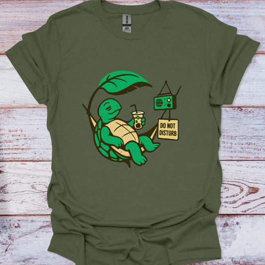 Green t-shirt with a turtle graphic and 'Do Not Disturb' sign on a wooden surface