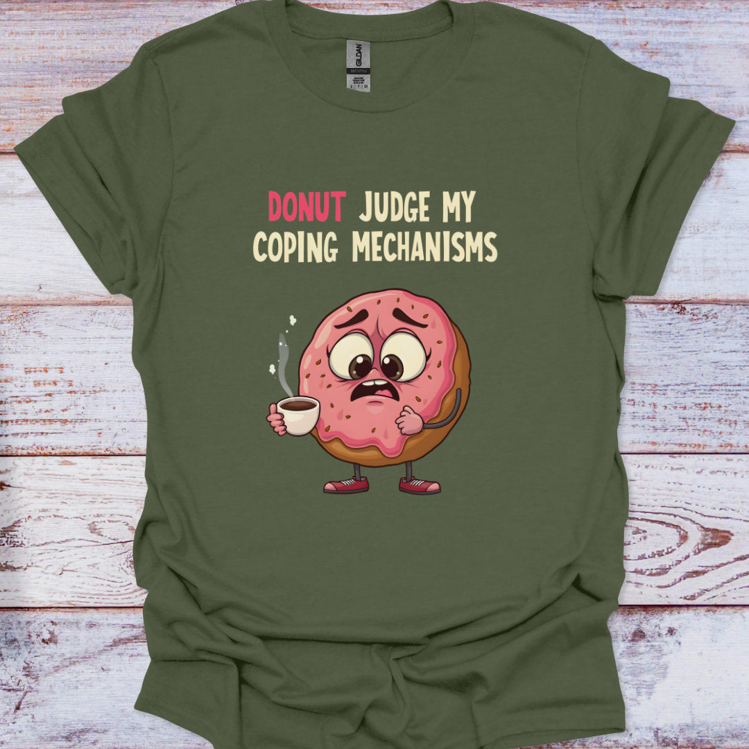 Green t-shirt with a cartoon donut holding coffee and text 'Donut Judge My Coping Mechanisms' on a wooden surface.