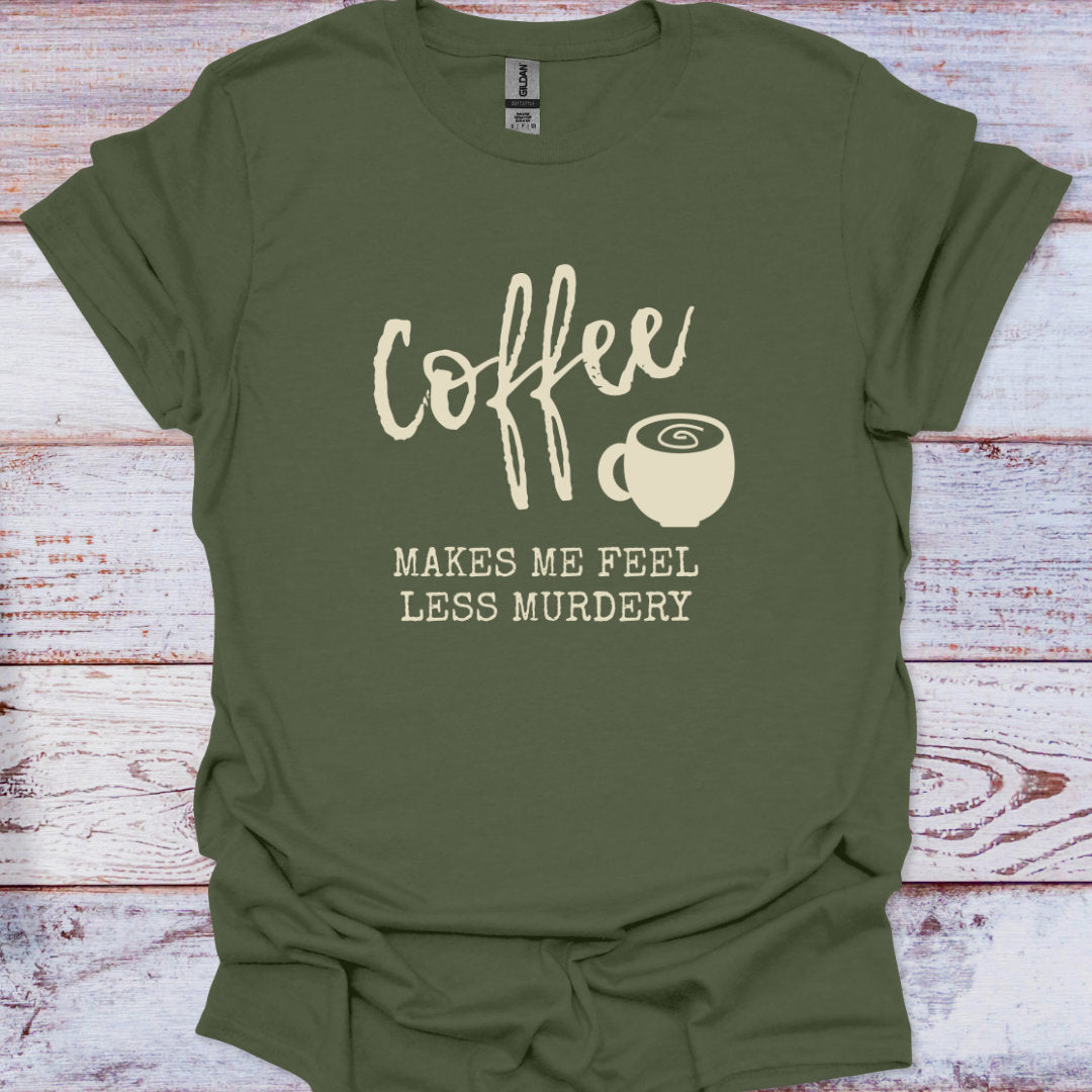 Green t-shirt with 'Coffee makes me feel less murdery' text and coffee cup graphic on a wooden surface