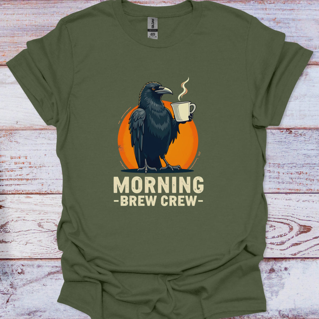 Green t-shirt with a crow holding a coffee cup and 'Morning Brew Crew' text on a wooden surface