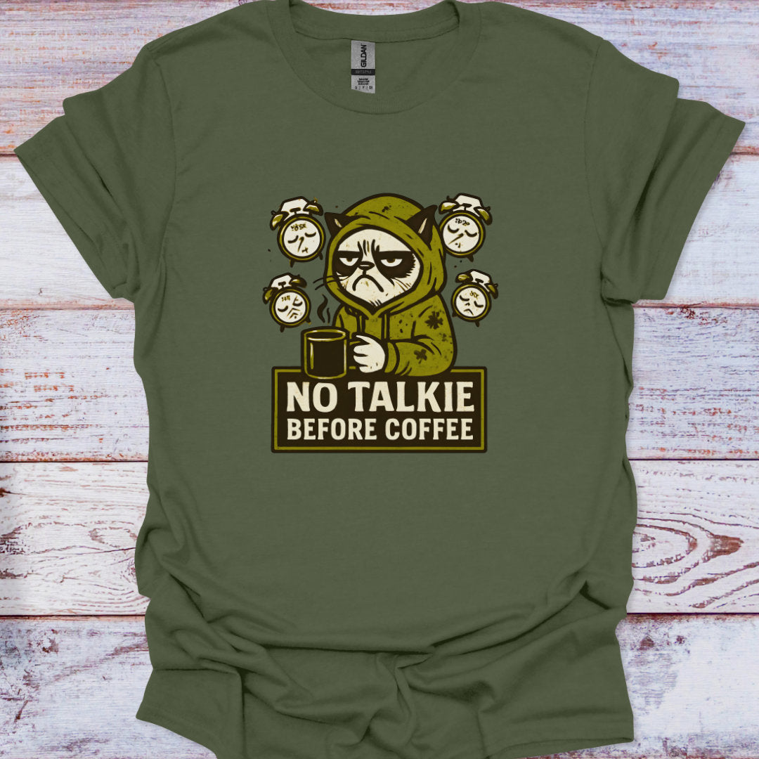 Green t-shirt with a graphic of a character holding a coffee cup and text 'No Talkie Before Coffee' on a wooden surface.