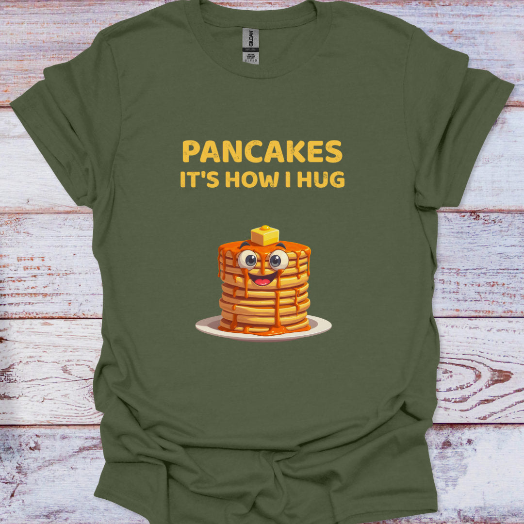 Green t-shirt with cartoon pancakes and text on a wooden surface
