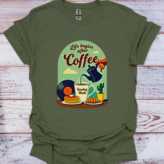 Green t-shirt with a graphic design of coffee-themed illustrations on a wooden surface.