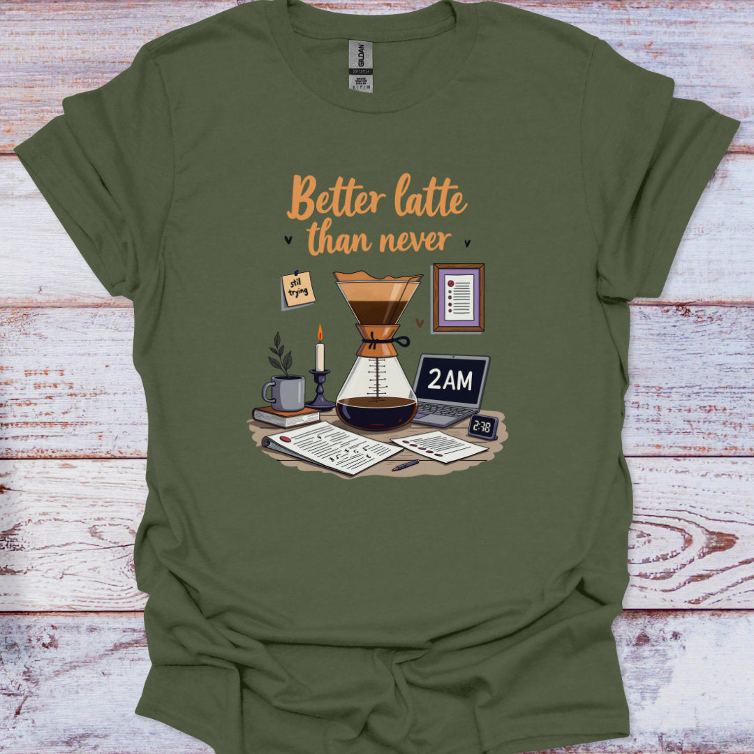Green t-shirt with coffee-themed graphic and 'Better latte than never' text on a wooden surface.