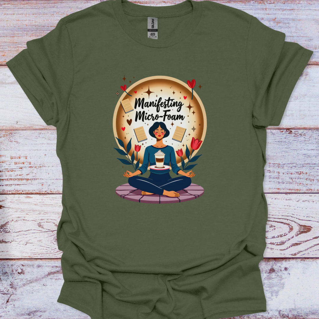 Green t-shirt with a graphic of a person meditating and text 'Manifesting Micro-Foam' on a wooden surface.