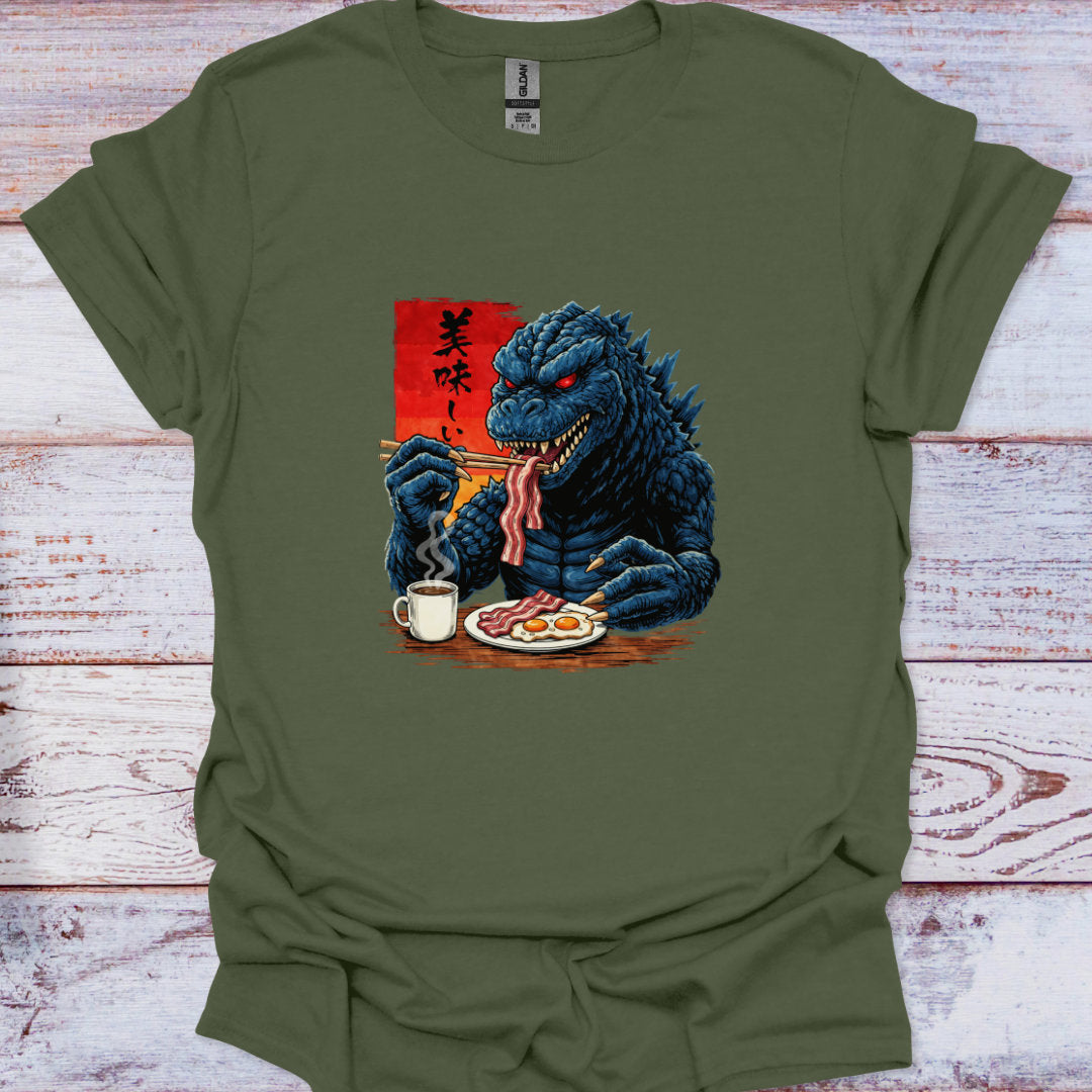 Green t-shirt with a graphic of a kaiju dragon eating breakfast on a wooden surface